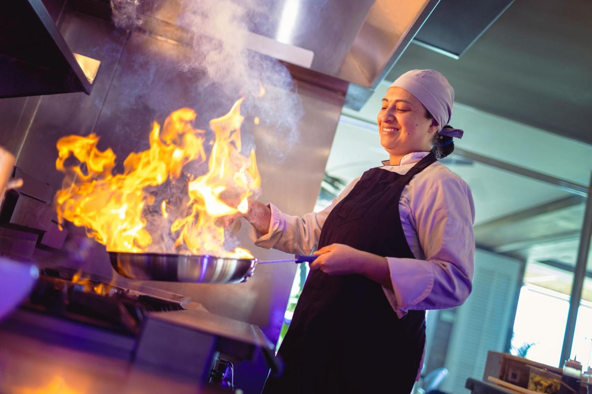 산타 마르타 메리어트 리조트 플라야 도르미다 산타마르타 외부 사진 A chef cooking with a flaming skillet