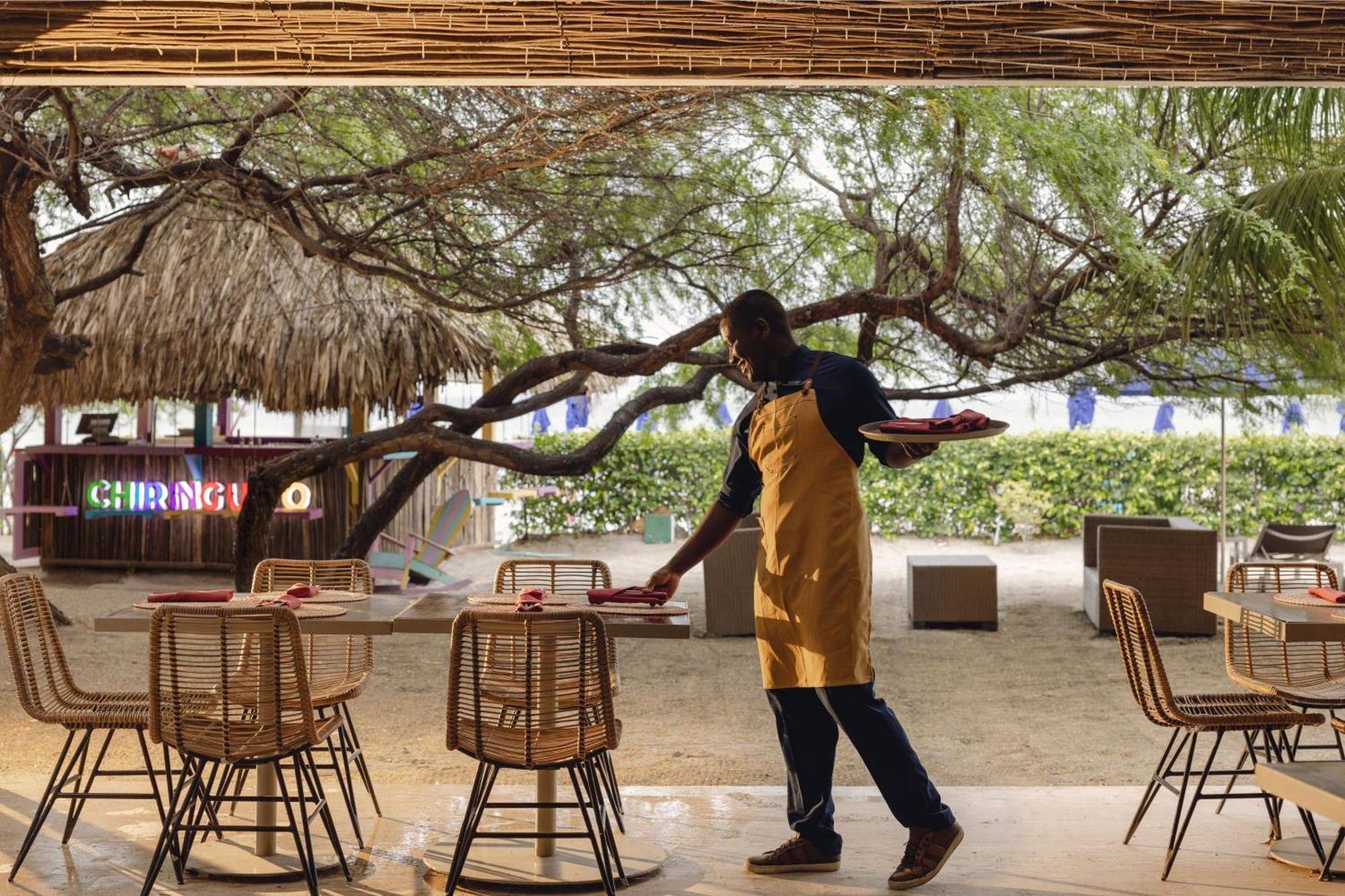 산타 마르타 메리어트 리조트 플라야 도르미다 산타마르타 외부 사진 A waiter clearing a table